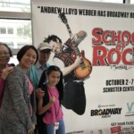 Taking a picture in front of the School of Rock poster with my grandparents
